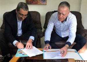 image of Two Men Signing Documents Together