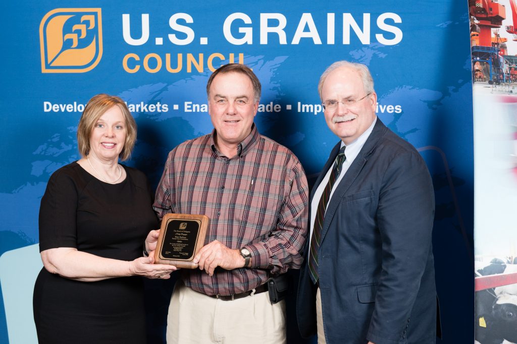 Brian Baalman receiving an award from two other people