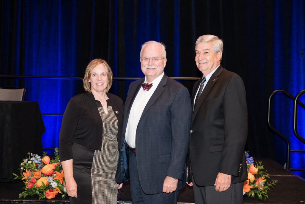 Image of one woman and two men on a stage