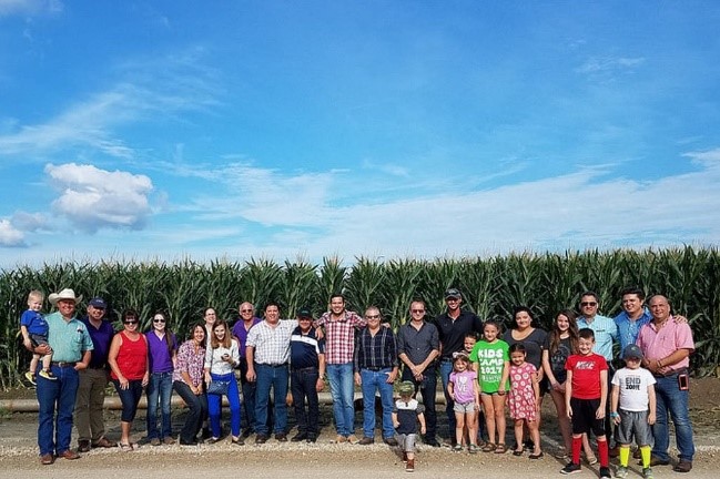 image of a group of people standing in front of a corn field