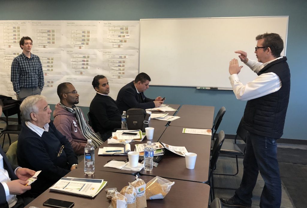 photo of several man listening to a man speak