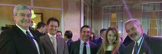 group photo of 3 men and 1 woman at a reception