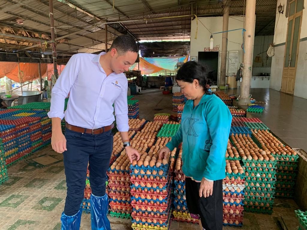 Caleb in Vietnam- man and woman standing in facility inspecting eggs