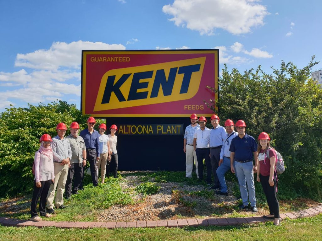 Tunisia Trade Team- group photo of team members standing in front of plant logo sign