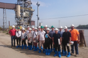 group photo of team members standing at a plant