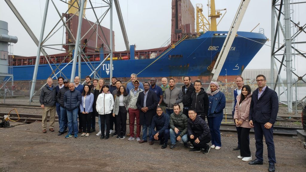 MEA Team- group photo of team members in front of a cargo ship