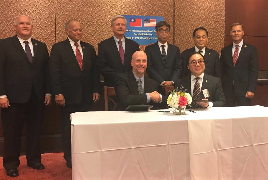 Signing of Goodwill Mission Taiwan- 6 men standing, 2 seated shaking hands