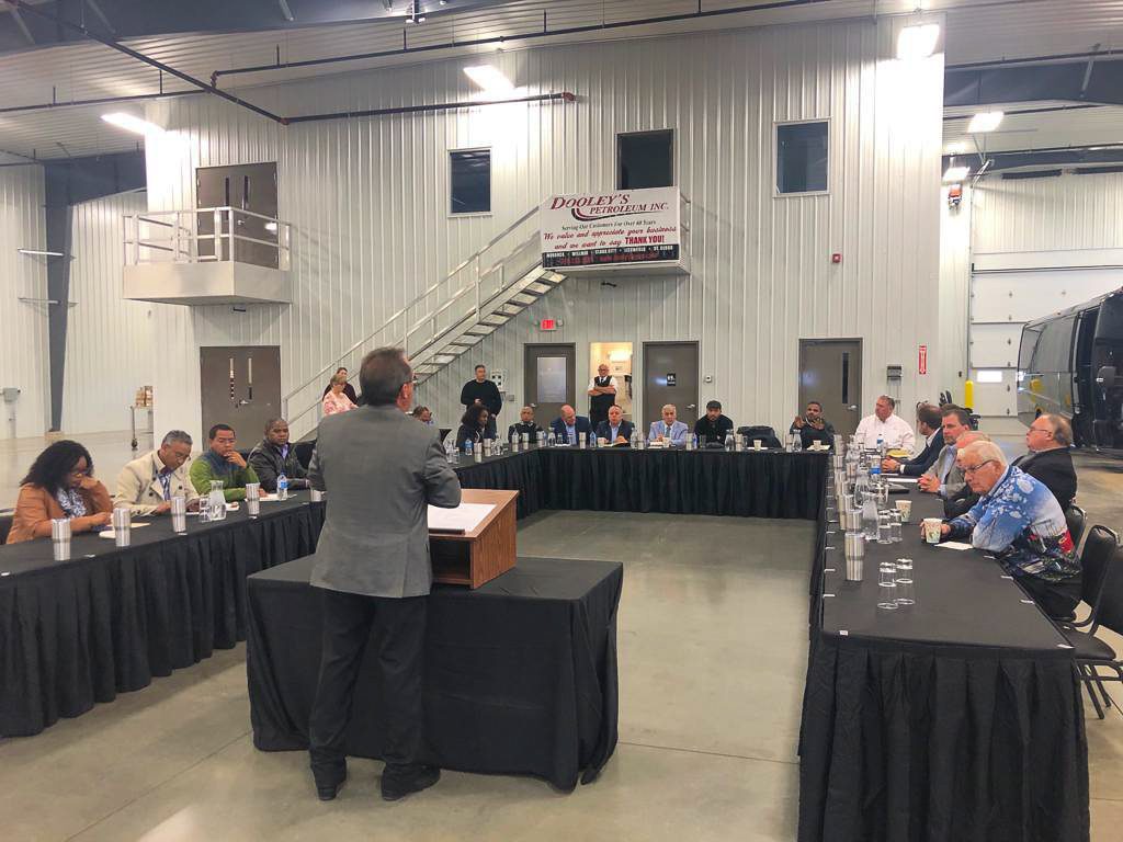 Global Ethanol Summit - Post-Tour, man speaking to group of attendees who are seated in a warehouse
