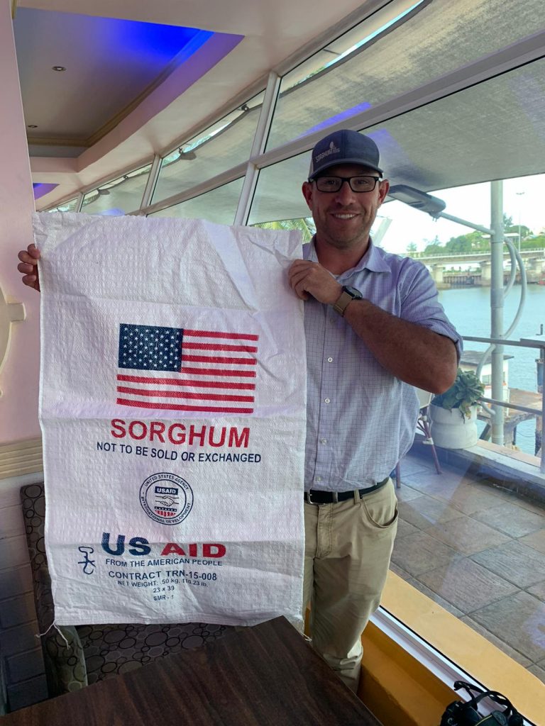 a man holding a bag for sorghum