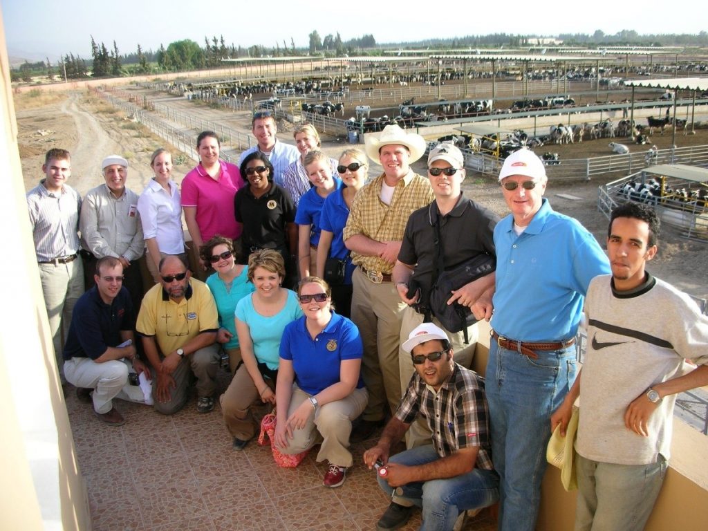 19 People Standing In Front of Cow Farm