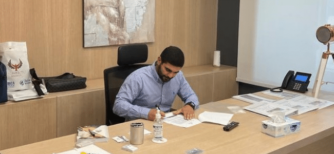 Man Signing Documents on Wood Desk