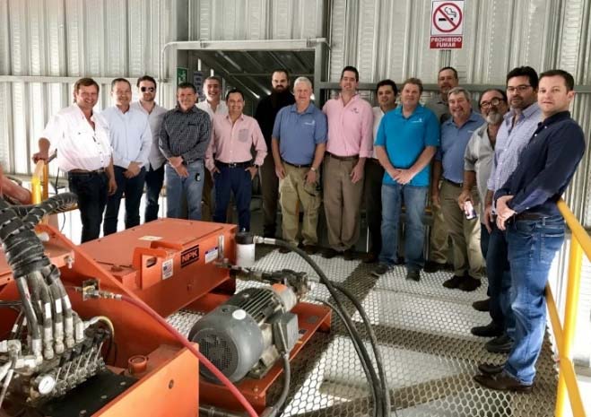 A group of men standing next to some machinery