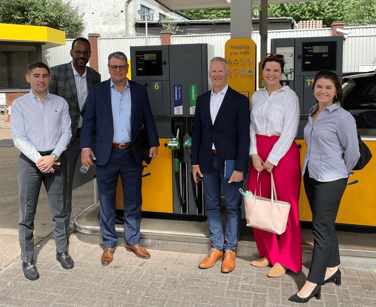 image of six people posing at a gas pump