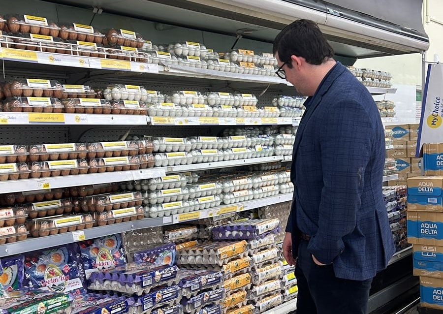 image of a man examining eggs in a grocery store