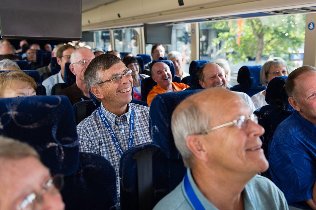 image of people smiling on a bus
