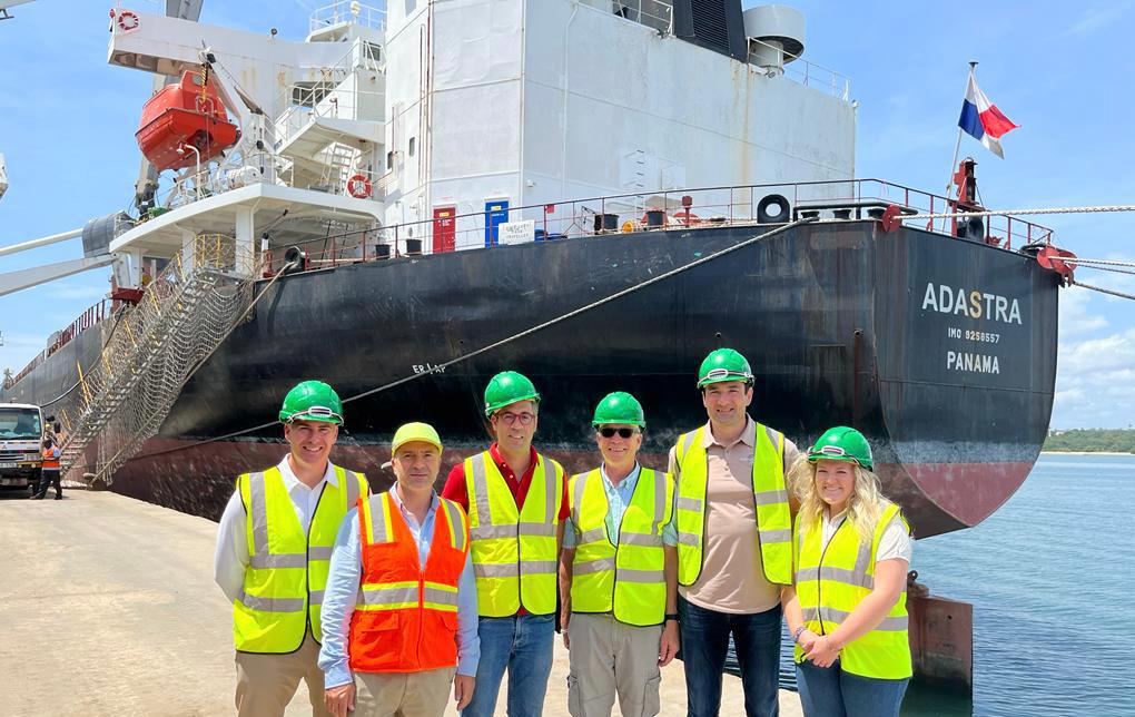 A group of people in front of a cargo ship