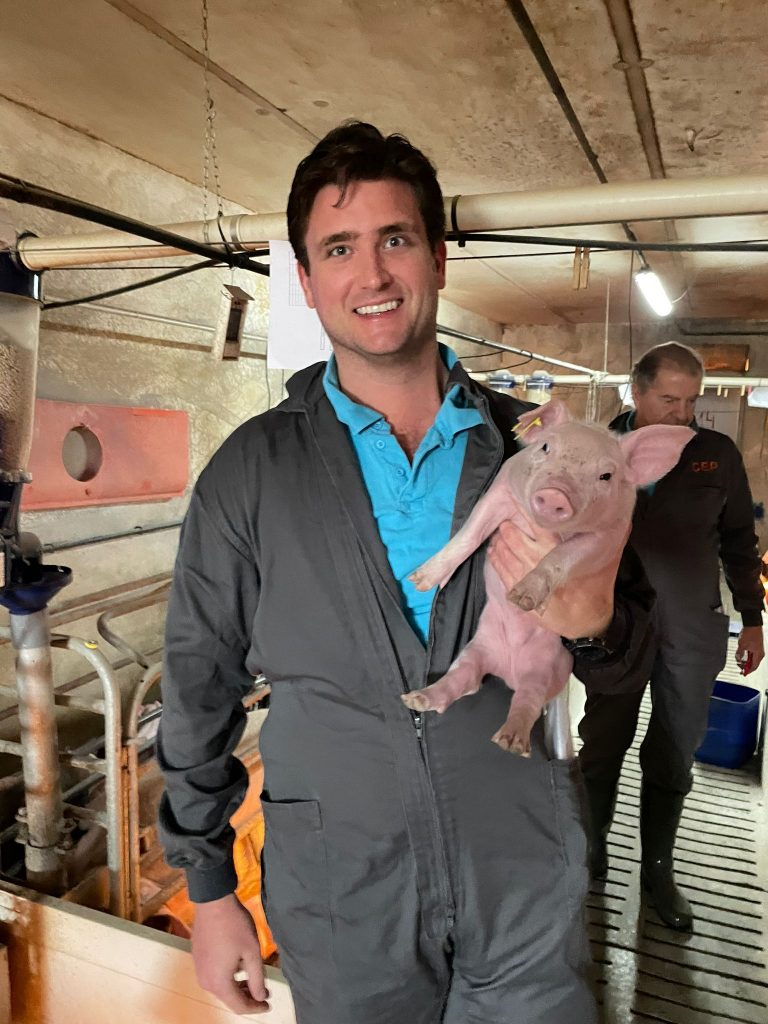 A man holding a small pig