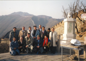 A group of people standing in front of the Great Wall of China