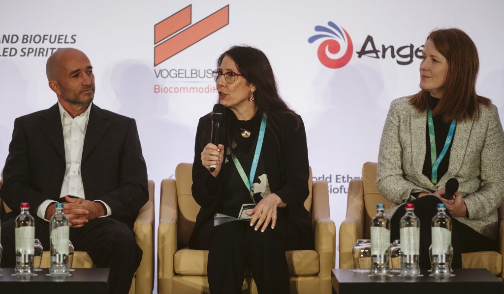 A woman holding a microphone on a conference stage